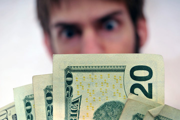 Man staring at a wad of cash