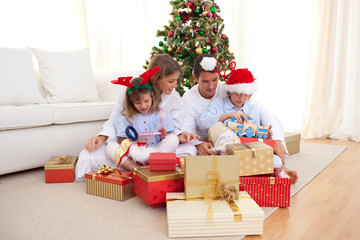 Obraz na płótnie Canvas Young family unpacking Christmas presents