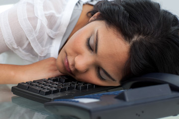 Young businesswoman sleeping on the keyboard