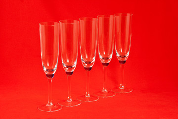 Five champagne glasses on red background