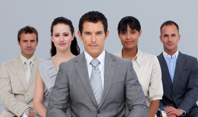 Multi-ethnic business team sitting in front of the camera