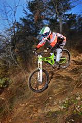 A young man riding a mountain bike downhill style