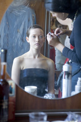 bride before wedding at home doing make up looking in mirror