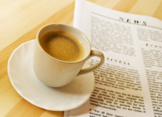 A cup of hot coffee, and newspaper.