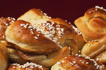 Group of fresh cinnamon buns with pearl sugar.