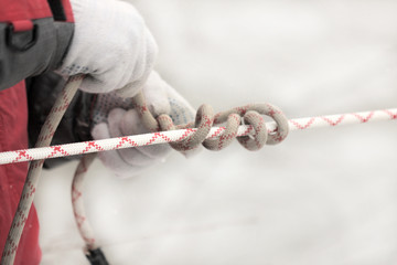 man tying a knot in a climbing rope