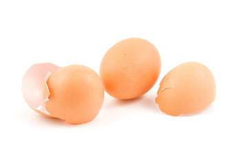 Whole egg and broken shells over white background