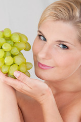 Young healthy woman with white grapes