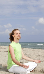 Fototapeta na wymiar man meditating on beach