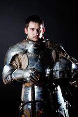 Foto auf Leinwand Großer Krieger mit Schwert und schwerer Rüstung © Fxquadro