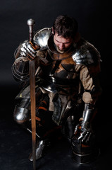 Grand chevalier tenant son épée et son casque