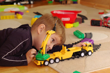 Naklejka premium Small boy playing with toy truck