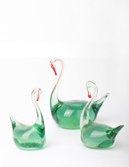 Glass green figures of swans isolated on a white background