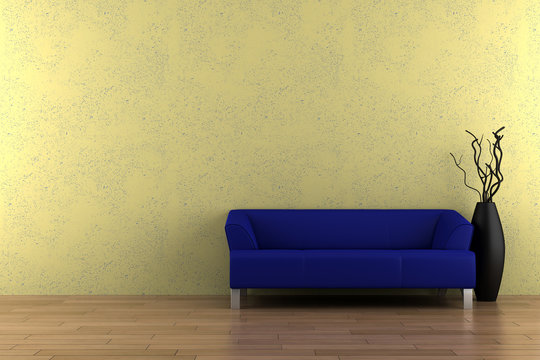 blue sofa and vase with dry wood in front of yellow wall