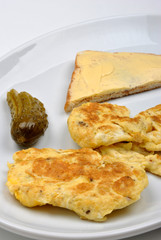 scramled eggs, gherkin and toast on a plate
