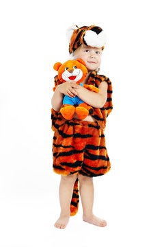 The little boy in a suit of a tiger and a toy tiger