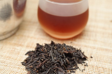 Cup of tea and black tea leaves