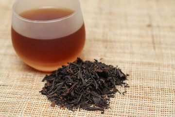 Cup of black tea and tea leaves