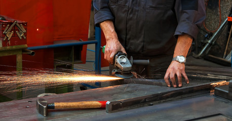 Arbeiterhände in der Metall Industrie mit Trennschleifer