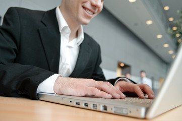 hände von business mann tippen auf laptop tastatur in büro