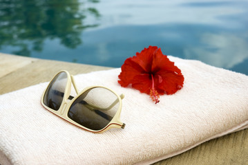 Sunglasses and towel at the poolside © Nicole Hofmann