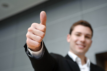 mann in anzug zeigt freundlich gestreckten daumen