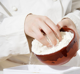 hands pouring flour for a cake