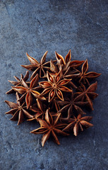 A symetric pile of star anise on a blue slate b/g