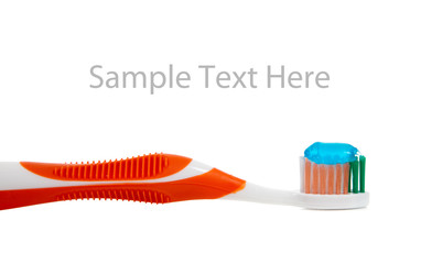 orange toothbrush and toothpaste on white