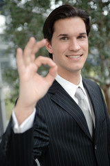 mann in anzug zeigt mit fingern freundlich o.k. zeichen