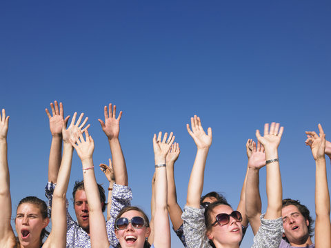 Enthusiastic People with Arms Raised