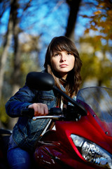 Fototapeta na wymiar The brunette girl on the red motorcycle