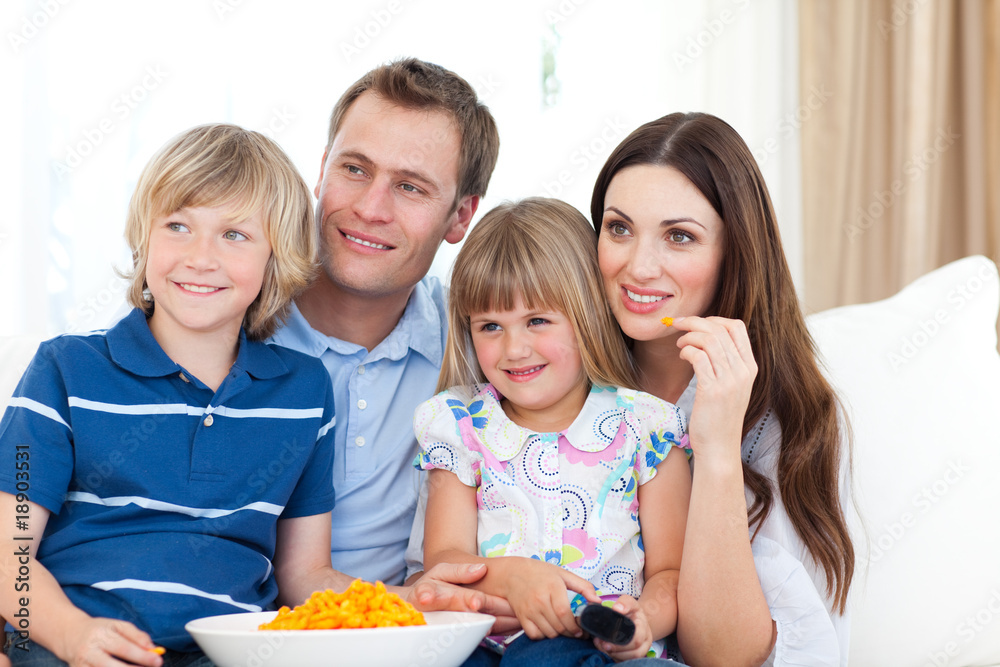 Wall mural Family watching television and eating chips