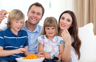 Happy family eating crisps