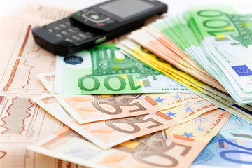 euro notes and black mobile phone on a financial newspaper
