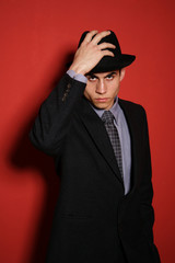 Young man in suit over red wall