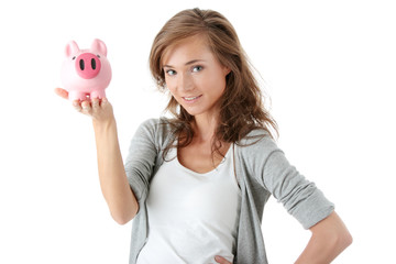 Fototapeta na wymiar Young beautiful woman standing with piggy bank