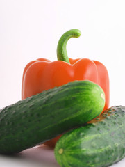 Red Bulgarian pepper and two cucumbers on a white background