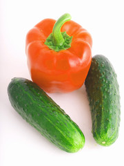 Red Bulgarian pepper and two cucumbers on a white background