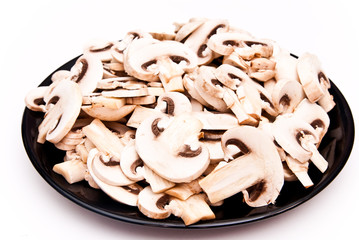 champignon mushrooms cutted to pieces on the black plate