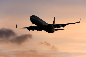 Fototapeta na wymiar Airliner silhouette, in flight at sunset.