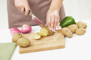 Female hand chopping potatoe