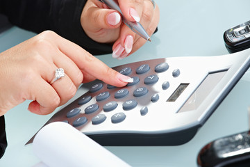 Female hands using calculator