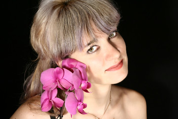 beautiful woman holding an orchid near the face