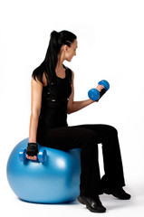 Attractive muscular brunette sitting on fitness ball