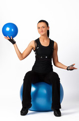 Brunette sitting on fitness ball with blueball
