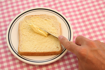 Busy buttering a slice of bread