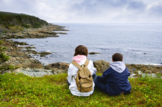 Children sitting at Atlantic coast in Newfoundland