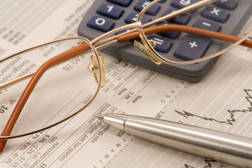 Business still life with pen, glasses and calculator