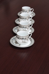 Four graceful cups with an ornament on a table